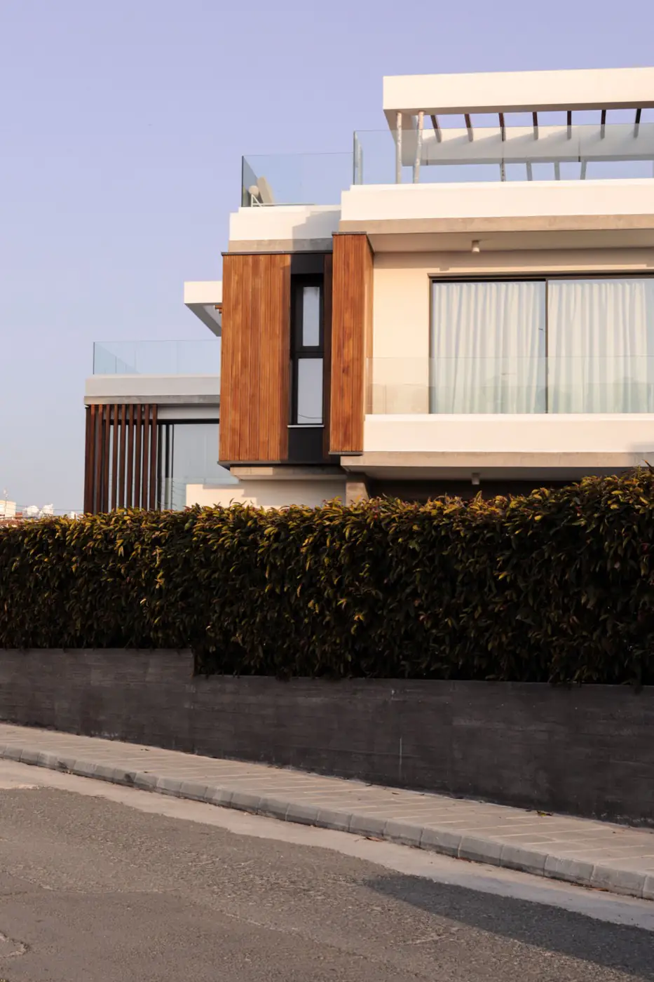 Fachada de vivienda unifamiliar con revestimiento de madera y acabado blanco